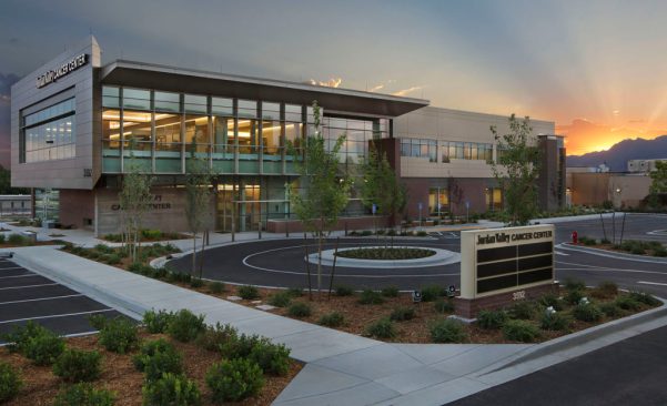 The south-facing exterior at dawn showcases the outdoor healing gardens and large floor-to-ceiling windows, telegraphing mountain views and natural light to the interior.