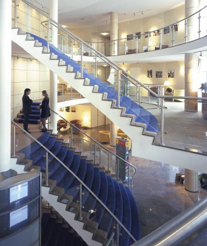 A corporate conference center for Shell in The Hague, Netherlands, functions as a hotel and training center for employees during the week and is open to the general public during weekends. Shared spaces inside and outside an office building maximize the utilization of space and technology while providing social benefits.