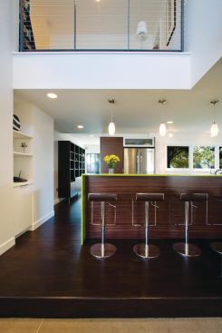 The home’s interiors reflect the contemporary exterior aesthetic, with salvaged oak flooring, reconstituted wood veneer cabinetry, and recycled glass terrazzo countertops.