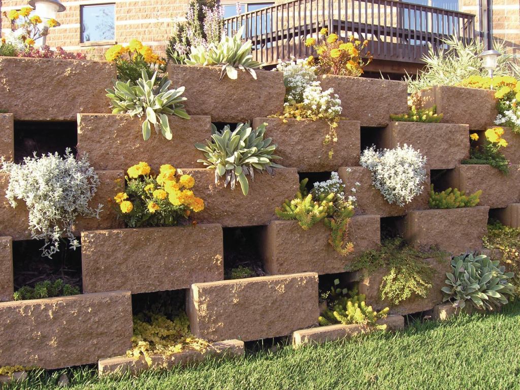 The Versa-Lok Versa-Green Plantable Wall System combines the strength of a segmental retaining wall with the lush beauty of a hanging garden. Each concrete unit weighs 70 pounds and covers nearly 1 square foot of the face of the wall. Inside each unit is a 6"-deep cavity for planting. A groove along the top accommodates irrigation tubing that runs across each course parallel to the wall face. versa-lok.com