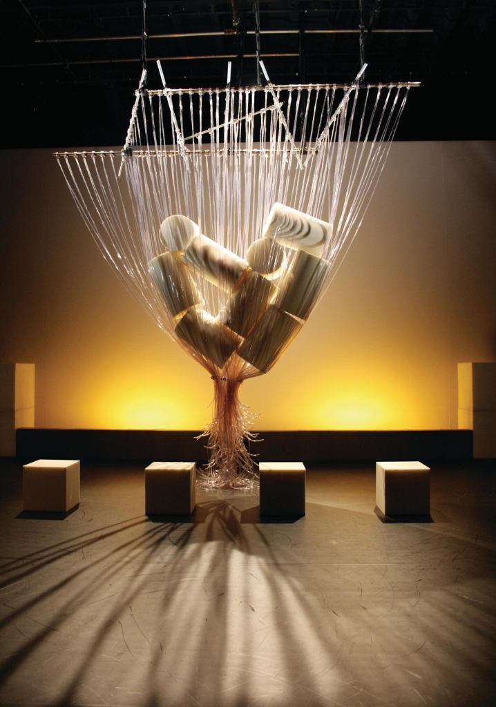 The PVC tubing "becomes an environment for the piece," co-collaborator Seth Harrison says. Initially gathered together as "Anchises' bag," the tubes "are loosened, only to twine around performers and become a shimmering network." The square and cylindrical blocks function as props. "We were looking for materials that were flexible and soft, because of the broad range of ages in the cast," Ariane Lourie Harrison adds.