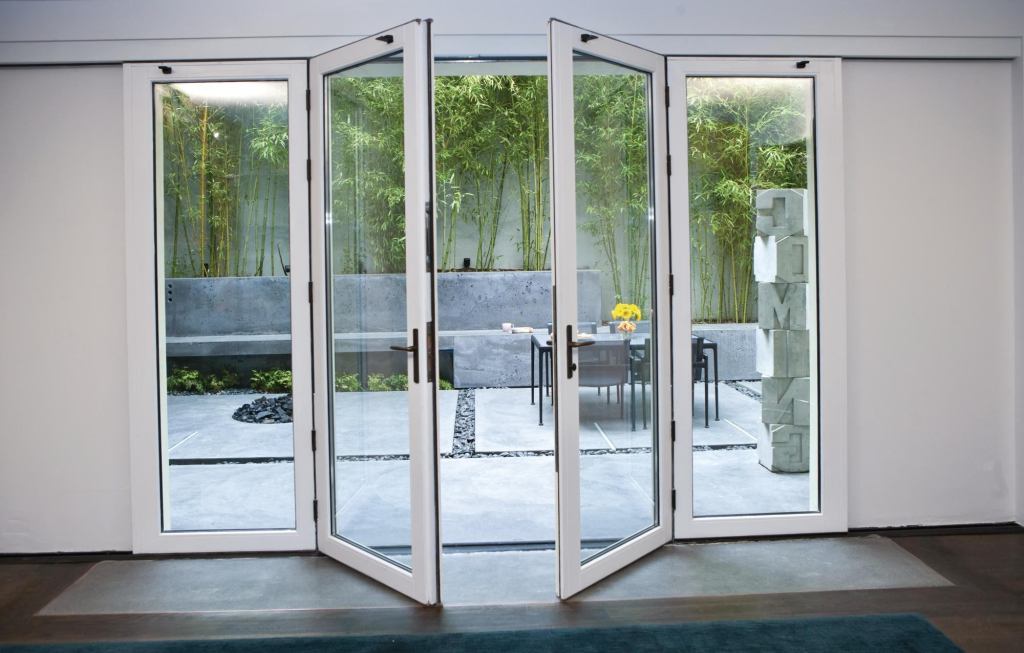 NanaWall Systems VSW65 single track sliding system with center swing doors combines the look and function of French doors with the ability to slide the doors to the side in a stack or so they disappear into a pocket. The multipanel system can glide open to create an opening up to 14' wide or be used as French doors with sidelights. The maximum sliding panel width is 4', and the maximum swing panel width is 3' 3". The maximum unit height is 9' 10". Hinges and sliding and multipoint locking hardware are concealed, and a variety of woods, glazing, divided lites, and hardware is available. nanawall.com