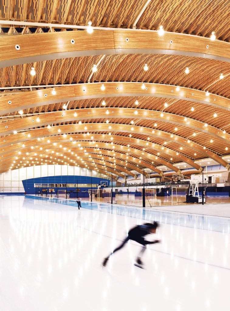 The roof of the Richmond Oval is made up of large Douglas fir glulam arches, with ribbed panels made from recovered wood devastated by a pine beetle infestation in the interstitial spaces.