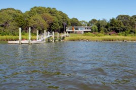 Our house appears to float above its river-side site