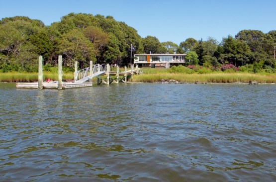Our house appears to float above its river-side site