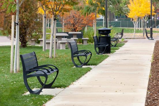 Trio Benches shown in 6 foot, backed configuration with Black Texture powdercoated frame, extruded aluminum slats and two armrests; also shown Urban Renaissance Litter & Recycling Receptacle in side opening with integrated recycle bin configuration at BART, Pleasant Hill/Contra Costa Centre Station, Walnut Creek, California