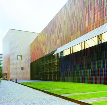 The brightly colored fa?ade of the Brandhorst Museum in Munich is made up of squareprofile ceramic sticks mounted in front of a folded metal cladding. Before pursuing this design, the architects also considered metal fabric, perforated glass, and a perforated ceramic scrim, all of which were rejected for cost or aesthestic reasons.