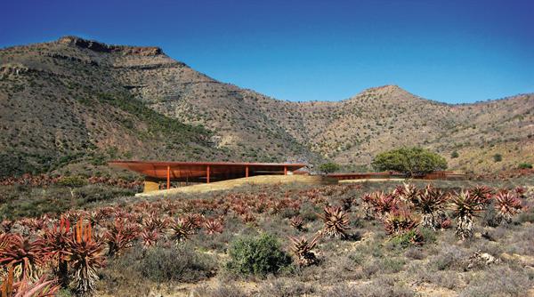 The planned Karoo Wilderness Center is a natural resource conservation-and-management center in the Karoo region of South Africa. Concrete walls and gum-pole-clad cupped roofs shelter conference areas, residences, lounges, and a theater, among other spaces.