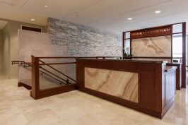 Reception desk and partition in ViviStone Cream Onyx glass with Pearlex finish at Burr & Forman, Orlando, Florida