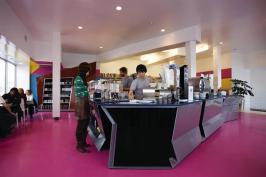 The custom counters were designed by Zago Architecture and fabricated locally. The laser-cut steel was powder-coated silver to give it a shine that reflects the surrounding colors, without resorting to a more expensive material that would have taken the project over budget. They also designed the butterfly display case on the back wall to ply the caf??s wares.