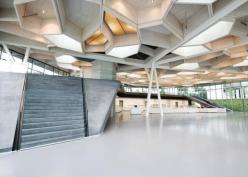 Each cell in the honeycomb ceiling of Barkow Leibinger's restaurant and event space is dedicated to a specific purpose, such as lighting or acoustics. Cells that incorportate luminaires are wired on different circuits, so that all the lights don't have to be turned on at once. Tubular speakers hang from some cells to distribute sound through the space during lectures, meetings, and concerts.