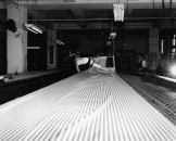 Garment worker laying out fabric to prepare for cutting