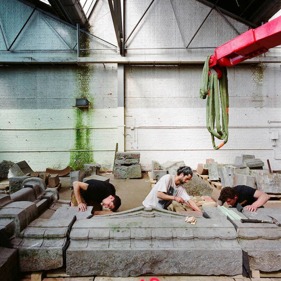 Craftsmen working to reassemble the façade of the Hotel Aubecq, 2010