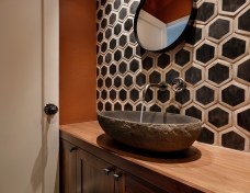 A wall to wall vanity houses below-counter storage. The oval stone sink is generously sized.