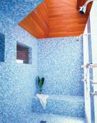 Materials that refer to sand and sea and improved views of the beach itself revive this 1970s Modernist bath.