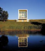 The 24-by-24-foot window wall on the home's large end feeds light into the interior. Standingseam metal (left) provides a sturdy cladding that suits the agricultural context.