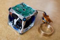 A prototype of a new modular robot, with its innards exposed and its flywheel — which gives it the ability to move independently — pulled out.