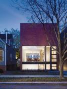 Fronted with a glass wall, the first-floor living space becomes an enclosed front porch.