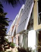 This six-unit project is sited on a narrow 50-foot lot, yet 22 feet are dedicated to an open courtyard. Delineated by bold colors, each unit has a four-story atrium skylight that also acts as a thermal chimney to pull warm air out of the interiors.