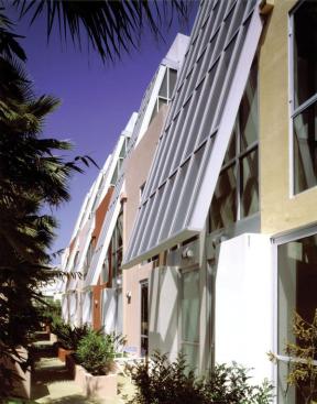 This six-unit project is sited on a narrow 50-foot lot, yet 22 feet are dedicated to an open courtyard. Delineated by bold colors, each unit has a four-story atrium skylight that also acts as a thermal chimney to pull warm air out of the interiors.