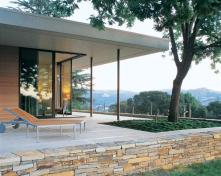 Sliding glass doors open up the corner of the master bedroom to views of the vineyard and mountains beyond. Ample terraces establish a close connection between house and site.