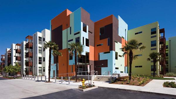 A daring exterior color palette highlights communal areas, such as a main entry and circulation zone, while more neutral hues let the residential components recede into the background.