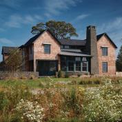 The architects responded to their clients  wish for a Saab like aesthetic with minimal detailing and subdued materials  weathered red cedar shingles, bluestone, and painted aluminum standing seam roofing.