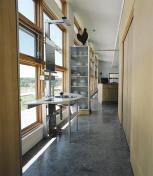 Clad in limestone panels and corrugated metal, the house hugs the contours of the landscape.