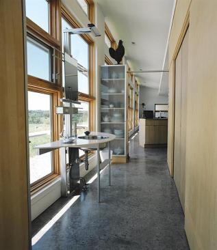 Clad in limestone panels and corrugated metal, the house hugs the contours of the landscape.