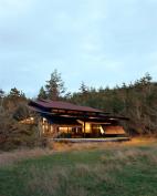 A system of lifting steel shutters protects this vacation home from intruders and the elements.