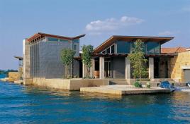 Located on a man-made lake where no shoreline setback applies, this house offers living spaces that reach into the lake itself.