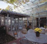 An old bakery conveyor belt undulates above the indoor tables (middle), concealing inexpensive light fixtures. Translucent glass awnings (top) add texture to the rear of the house.
