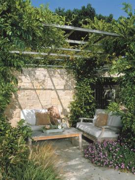 Tucked between the family room and the boat dock, the outdoor sitting area has clear views of the lagoon. Foliage and a stone wall provide shelter from the elements, and a steel gate leads to a handy outdoor shower for rinsing off after a swim.