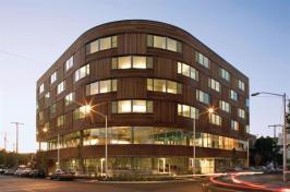 Ground-floor commercial space is topped by second-story common areas, with residences for cancer care patients taking up the upper levels.