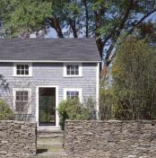 A stone wall at the front of the property joins the main house and guest cottage.