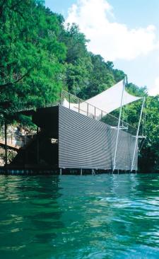 The boat dock's wall of steel tubes and stretched fabric roof lend it a feeling of lightness and transparency.
