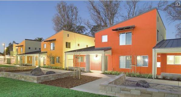 Bright exterior colors contribute to the projects cheerful atmosphere, while sloped roofs bestow a bit of high-ceilinged grandeur on the interior spaces. Each of the six townhouses accomodates four families, and an additional structure holds day care 