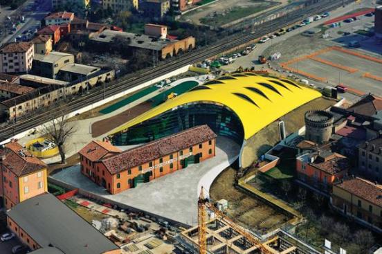 The+vivid+yellow+shell+of+the+new+Enzo+Ferrari+Museum+is+made+from+5%2c000+extruded+aluminum+pieces%2c+fitted+together+with+tongue-and-groove+joinery+by+shipbuilders+-+the+same+way+one+would+assemble+the+hull+of+a+ship.+The+shell+is+pierced+by+10+fins+to+create+computer-controlled+skylights+that+vent+warm+air+during+the+day.