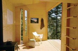 Built with recycled materials, the structure features an 8-foot-tall barn door, a wood stove, and laminate floors.