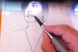 A photograph of the NeoLucida in use, demonstrating a subject's image superimposed on the drawing surface.