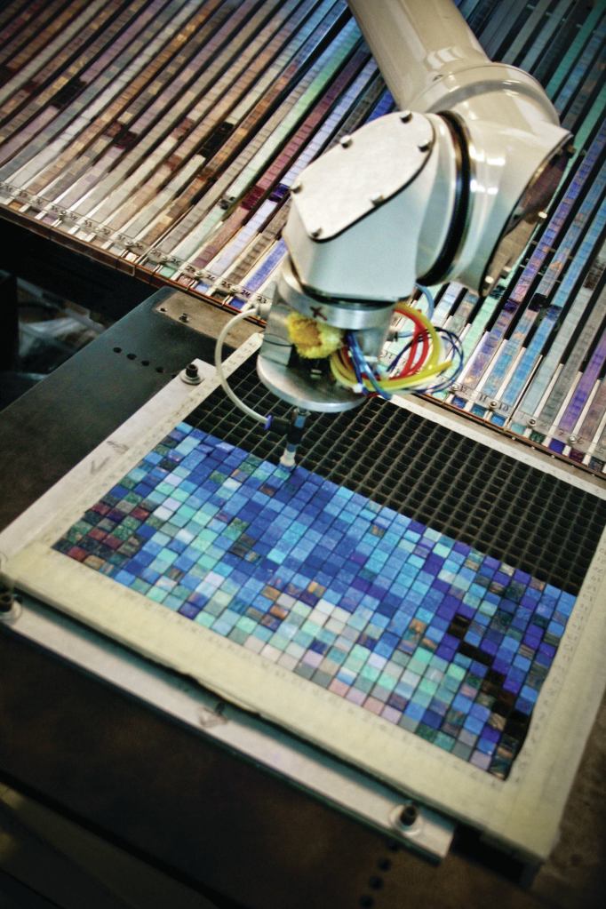 Artaic’s robot, which is named Arty, picks up and assembles individual mosaic tiles into 1-square-foot grids that are derived from the tesselated image file created in the company’s software. These grids of tiles are then anchored to backing to become a mosaic tile sheet. One large mosaic can comprise roughly 1,500 such sheets, which are installed on site.
