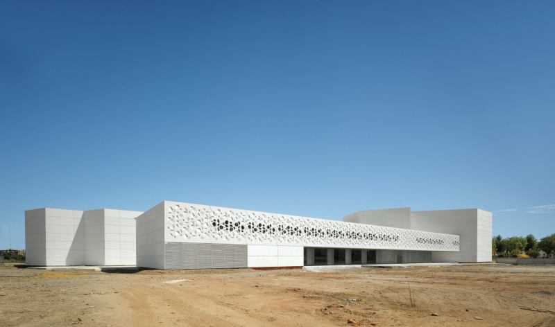 Polygonal perforations, abstracted from the building’s hexagon-based design, cascade across the exterior of the Contemporary Art Center in Córdoba, Spain, allowing natural light to dapple its interior.