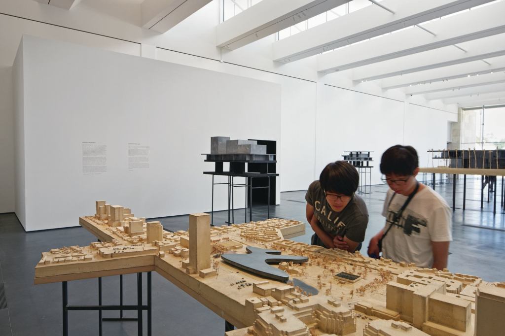 Visitors at LACMA’s Resnick Exhibition Pavilion survey Peter Zumthor’s proposed model for the museum campus.