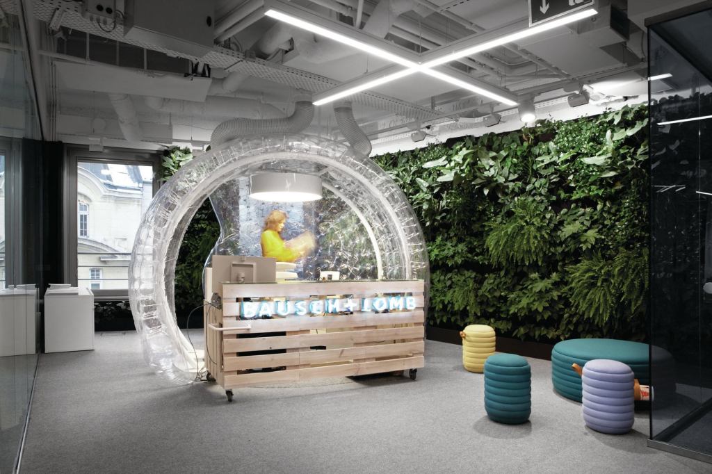 The pine-slat reception desk at the new Bausch + Lomb offices in Warsaw, Poland, is encased in an inflated vinyl bubble.