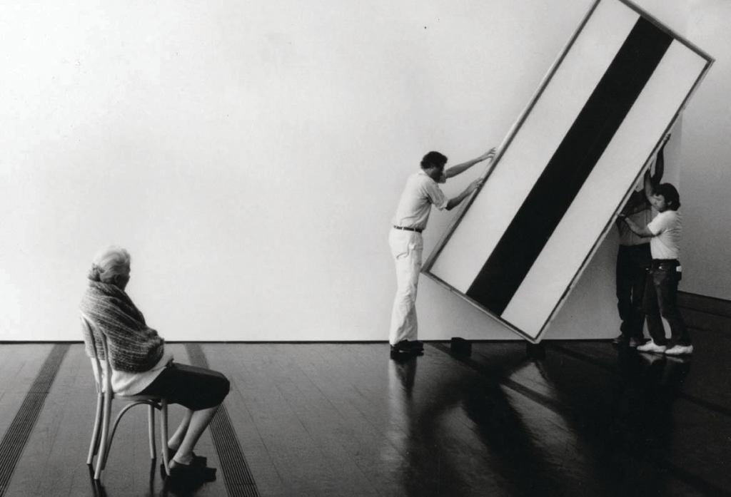 Dominique de Menil oversees workers as they hang a painting by Barnett Newman in the Menil Collection museum.