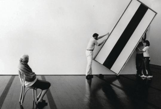 Dominique de Menil oversees workers as they hang a painting by Barnett Newman in the Menil Collection museum.