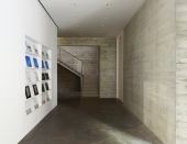 White walls for mounting artwork contrast with the stark concrete floors and walls.