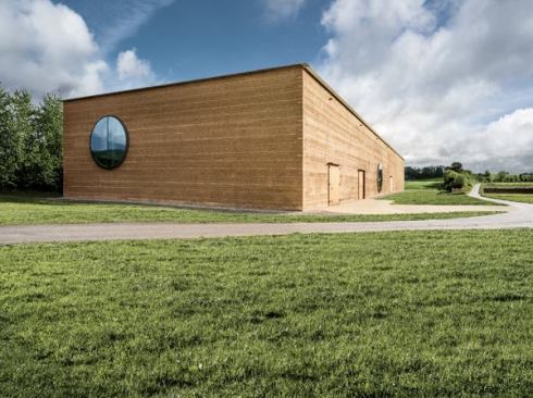 Rammed-earth walls support Ricola's new herb center in Laufen, Switzerland.