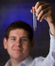 Alon Gorodetsky, an assistant professor of chemical engineering and materials science at the University of California Irvine, holds up a vial containing reflectin, a protein found in squid skin that could power biomedical and other electronic devices.