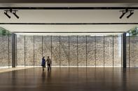 A former prison wall serves as a rugged backdrop for the streamlined events space.
